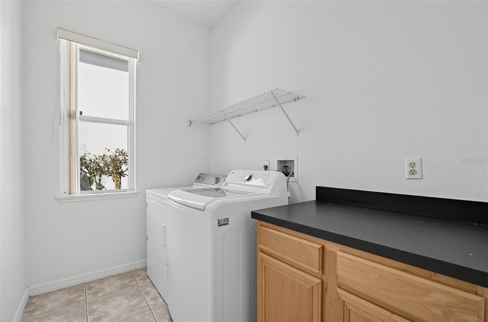 LAUNDRY ROOM WITH COUNTER SPACE, CABINETS, SHELVING, A LINEN CLOSET NOT SHOWN HERE AND A WINDOW FOR NATURAL LIGHTING. - 13838 RIVERPATH GROVE DR, ORLANDO