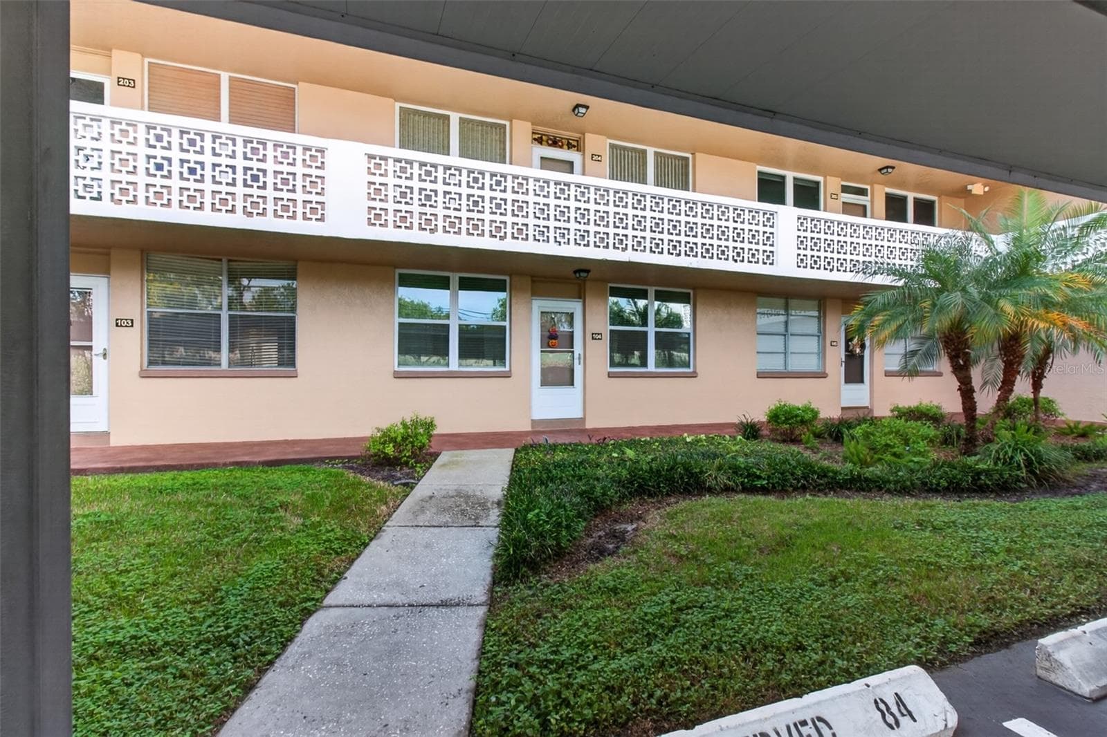 Front walkway from your covered deeded parking space #84 in front of the unit. - 5095 BAY ST NE #104, ST PETERSBURG