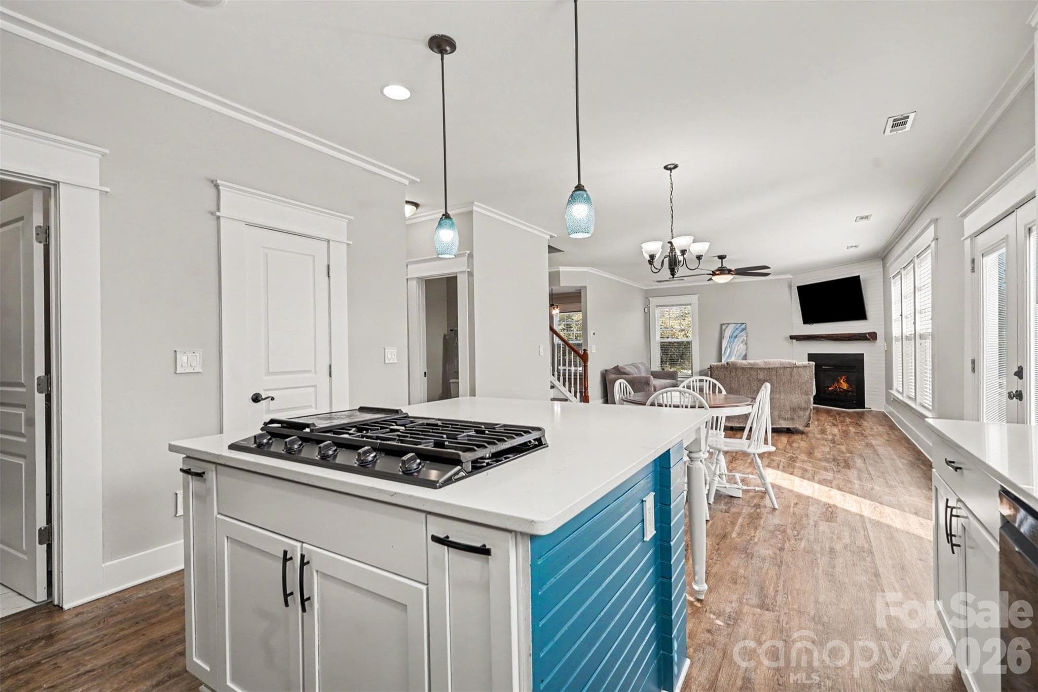 View of the kitchen into the Great Room. Large Island features built in gas range, Dual Pull Out Spice Racks on either side of the cooktopl. Fresh, neutural paint. - 3585 Leighton Drive SW, Concord