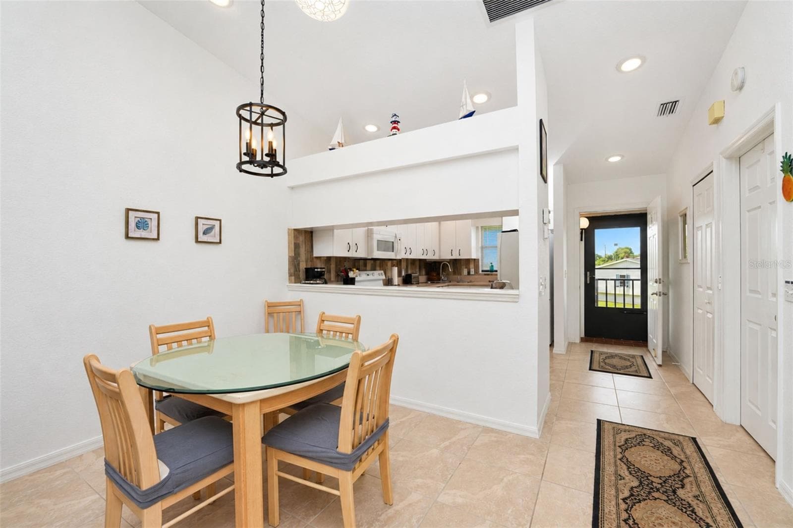 The dining area has a stylish lighting fixture and passthrough into the kitchen. - 4260 PLACIDA RD #9C, ENGLEWOOD