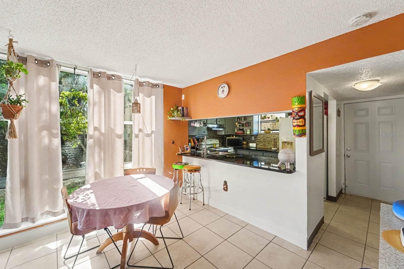 Spacious kitchen-dining combo with orange wall, white appliances & pass-through counter - 1055 ENCOURTE GREEN, APOPKA