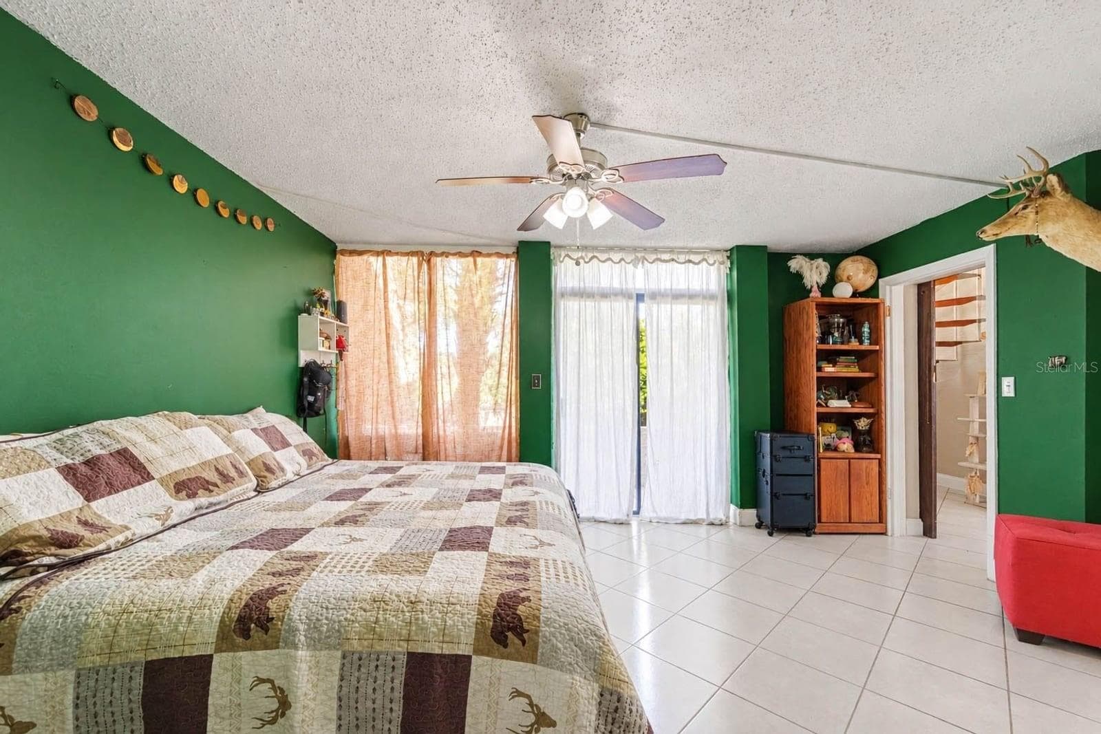 Master Bedroom with Green Walls, Mounted Deer Head & Sliding Glass Doors - 1055 ENCOURTE GREEN, APOPKA