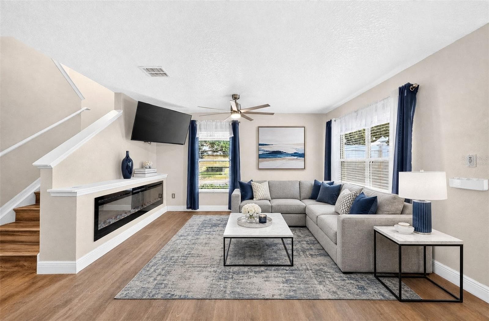 The Living Room makes a statement with its CUSTOM BUILT-IN ELECTRIC FIREPLACE (2025), adding warmth and ambiance to the space. Virtually Staged - 13028 AUBURN COVE LN, ORLANDO