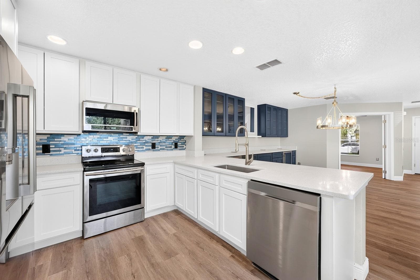 The Kitchen is equally impressive, featuring QUARTZ COUNTERTOPS, 42-INCH CABINETRY, a pantry closet and a breakfast bar perfect for casual meals or conversation while preparing dinner. - 13028 AUBURN COVE LN, ORLANDO