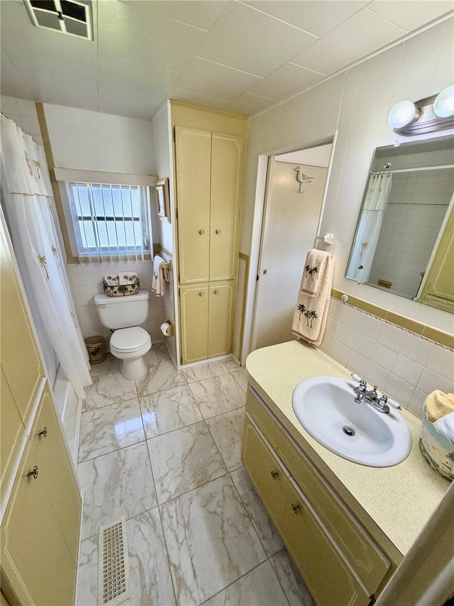 Hall bath entering from the hall. Door ahead leads to the 2nd bedroom - 34085 ALAMANDA DR N, PINELLAS PARK