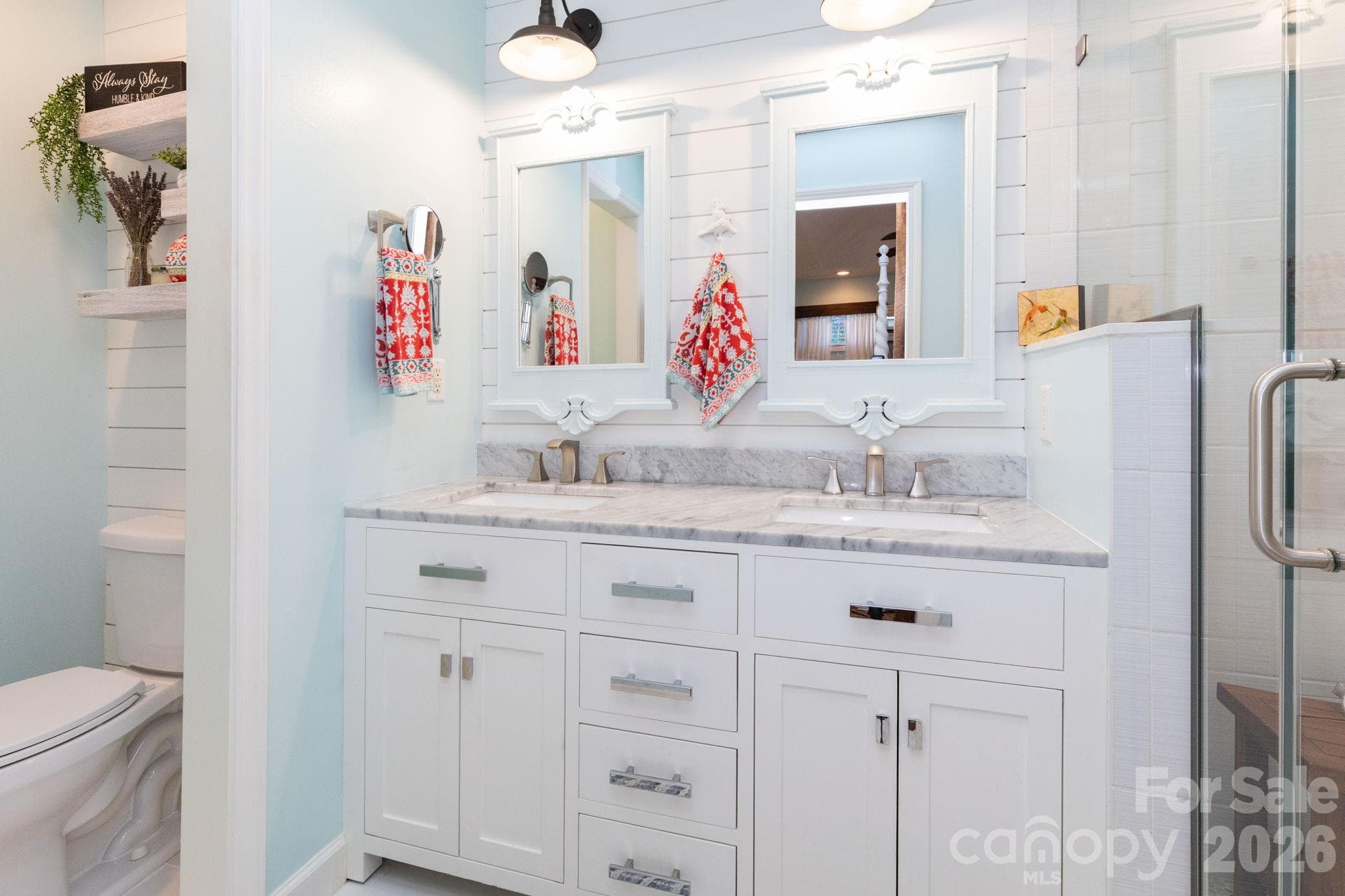 Primary bathroom featuring a double-sink vanity, generous cabinet and drawer storage, framed mirrors, and coordinating overhead lighting. - 139 Lone Eagle Lane, Hendersonville