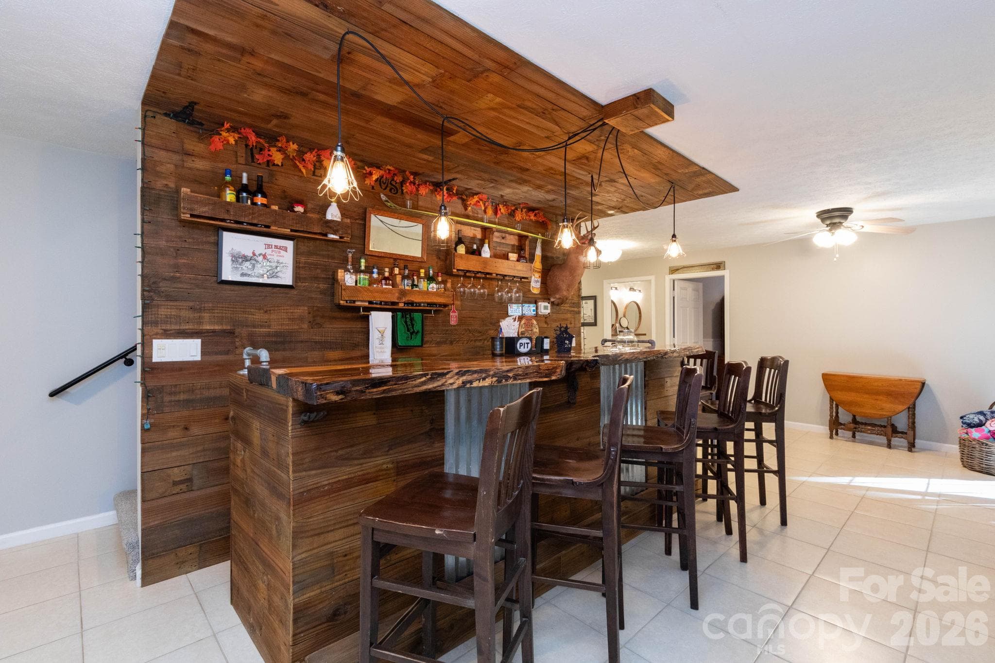 Custom bar area featuring rustic wood finishes, pendant lighting, open shelving, and generous seating space for entertaining. - 139 Lone Eagle Lane, Hendersonville