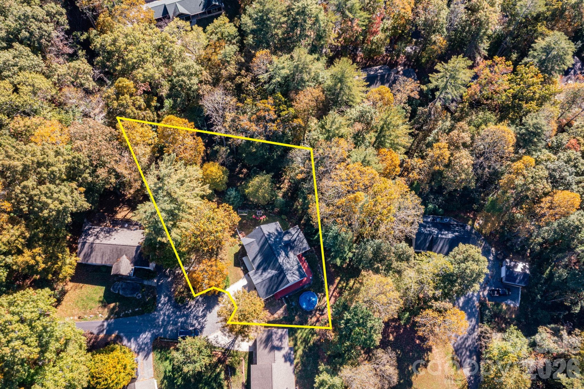 Overhead aerial showing the home, driveway, and wooded setting, with approximate property boundaries outlined for reference. - 139 Lone Eagle Lane, Hendersonville