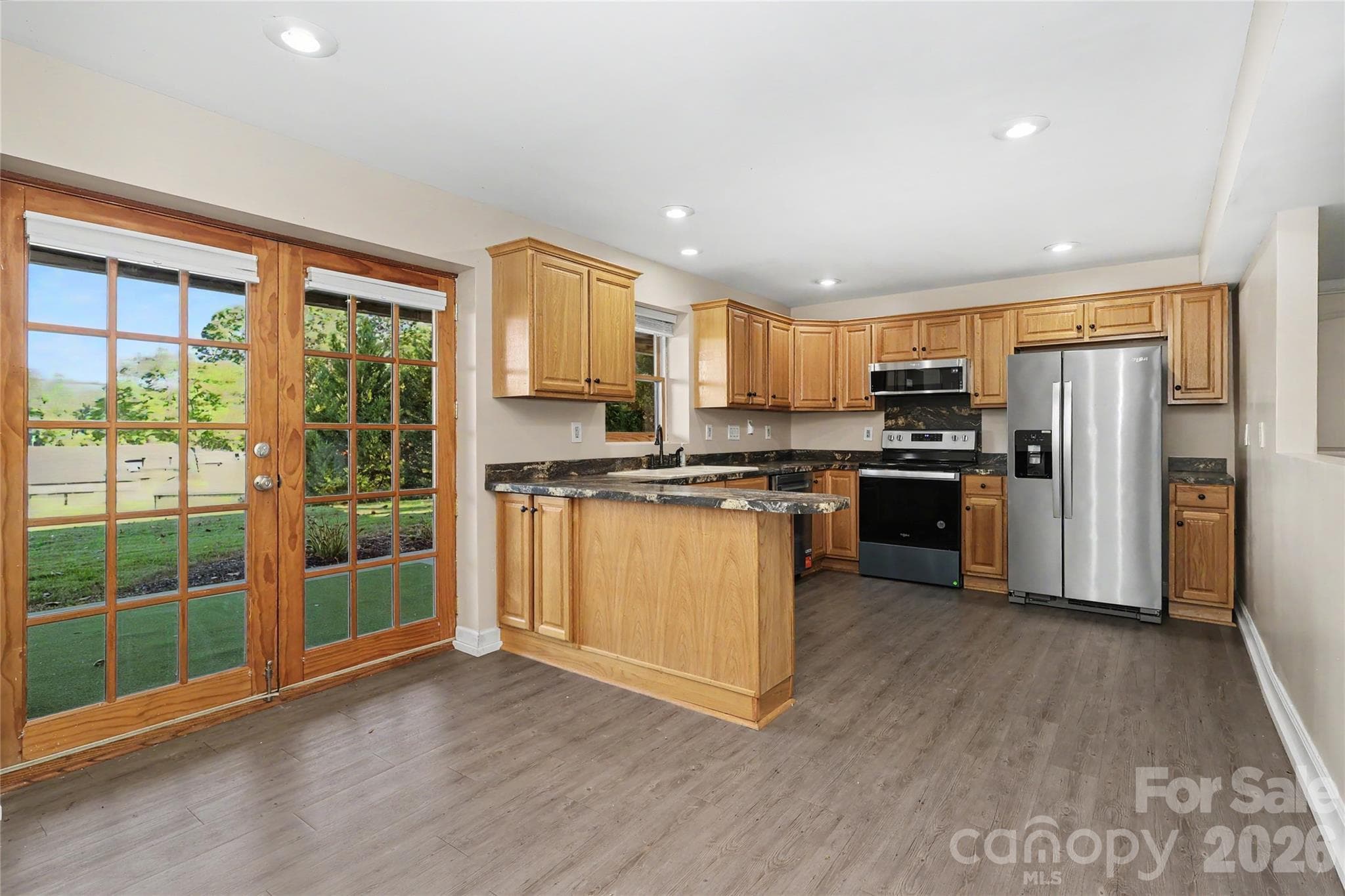 Lower Level - Kitchen with electric cooktop and oven, refrigerator and double doors leading to patio and large backyard. - 3121 Lakeside Circle, Belmont