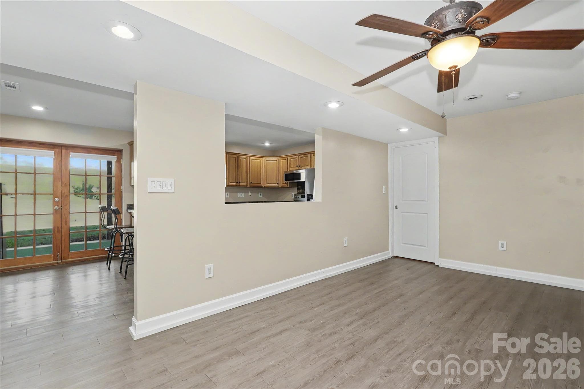 Lower Level Family Room with ceiling fan.  Door in background leads to a den, full bathroom and walk-in closet. - 3121 Lakeside Circle, Belmont