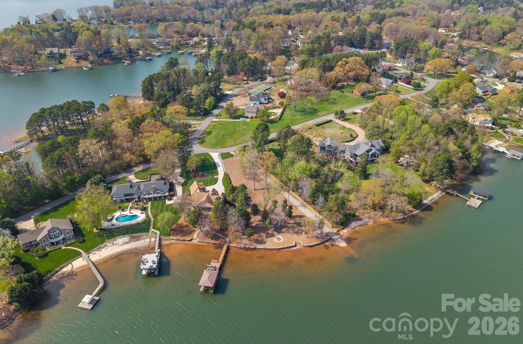 AERIAL PHOTO DIISPLAYING WATERFRONT STONE RETAINING WALL THAT HAS A FLAT STONE CAP TO ENHANCE THE BEAUTY WITH STEPS GOING INTO THE LAKE. THIS SHOT WAS TAKEN WHILE THE LAKE WAS APPROXIMATELY 6.5' LOWER THAN USUAL, SPRING/SUMMER 2026 - 841 Morrison Farm Road, Troutman