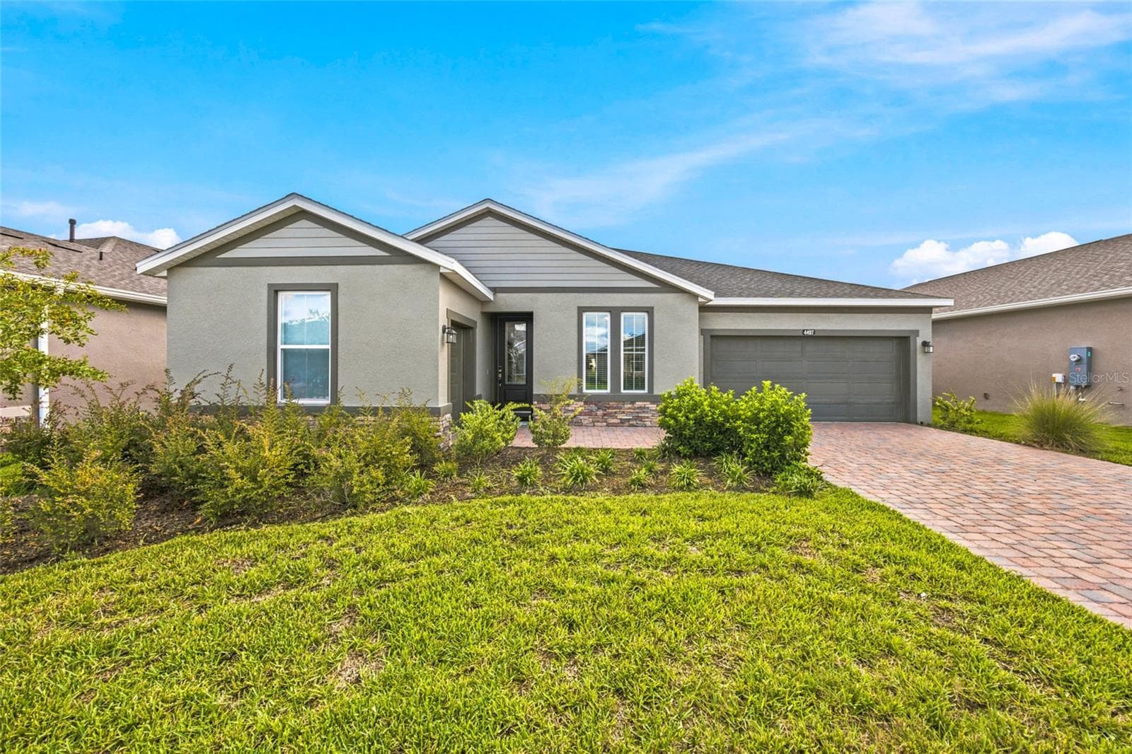 Welcoming front elevation with attractive landscaping, stone accents and a two-car garage. - 4497 NW 54TH TER, OCALA
