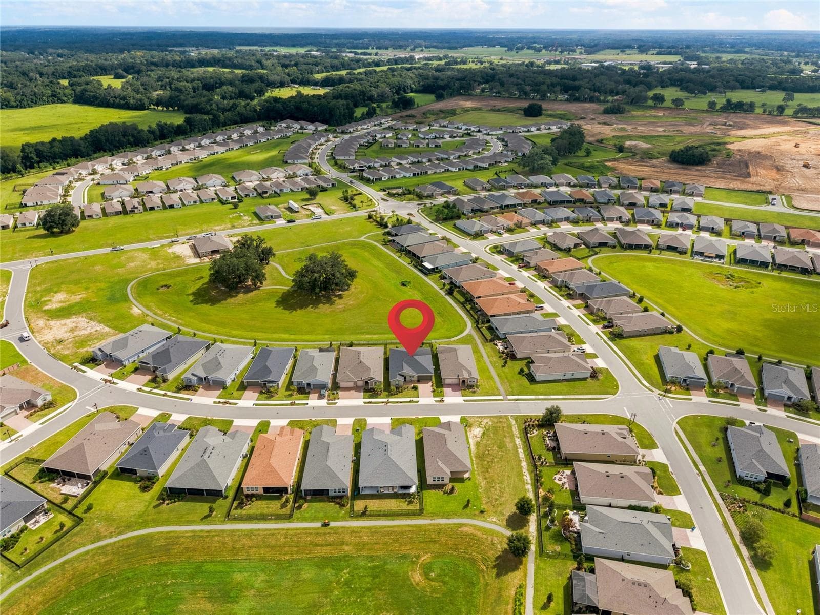 Aerial perspective highlighting the home's position beside the expansive neighborhood green space. - 4497 NW 54TH TER, OCALA