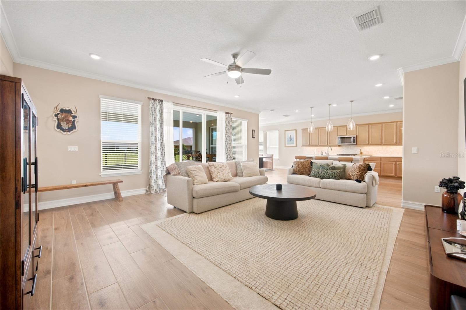 Additional living room perspective showcasing the open floor plan and sliding patio doors. - 4497 NW 54TH TER, OCALA