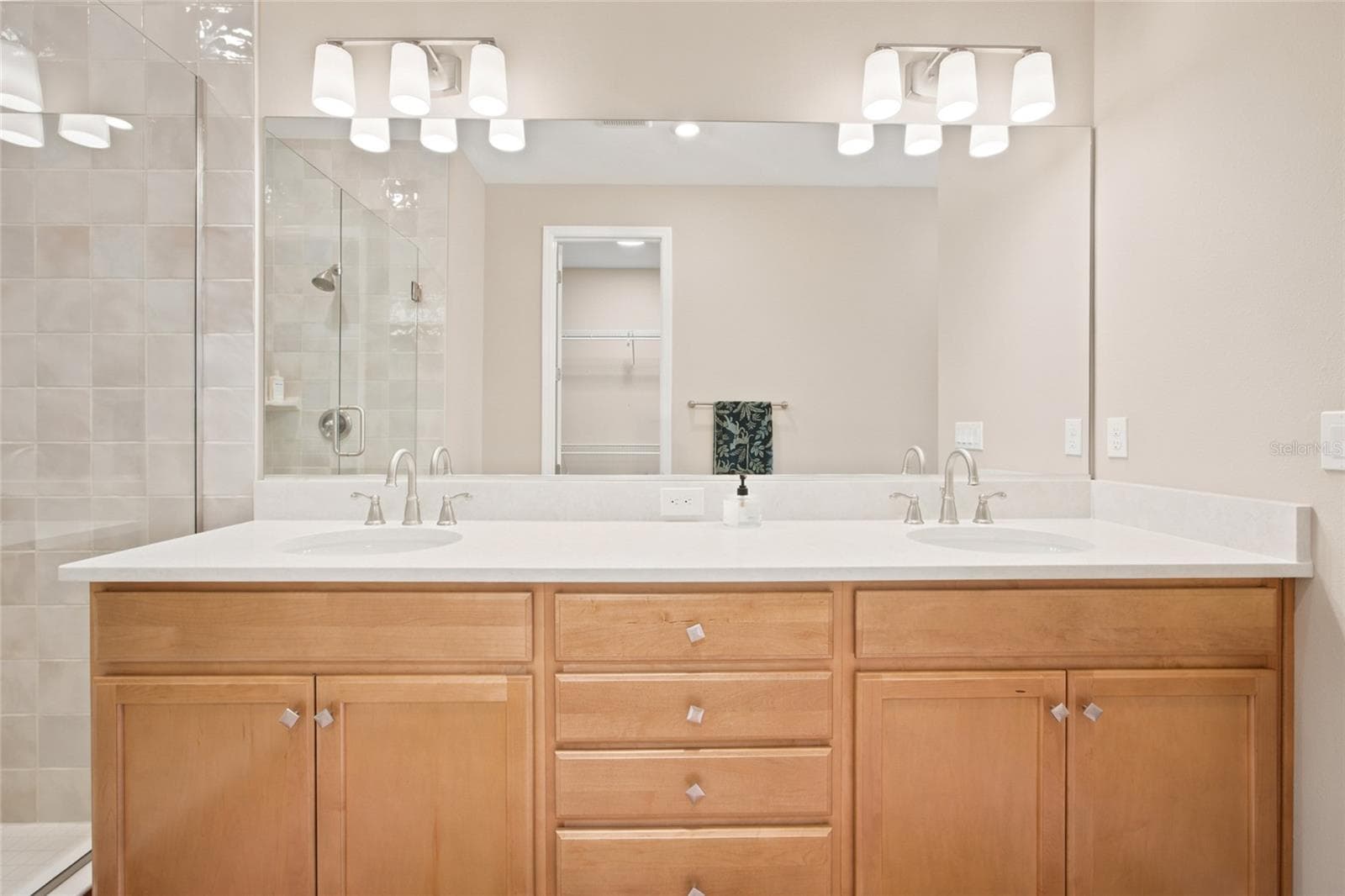 Double-sink vanity and large mirror in the primary bathroom. - 4497 NW 54TH TER, OCALA