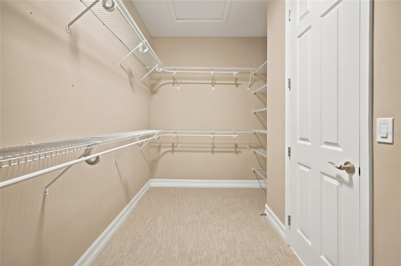 Generous walk-in closet with wraparound shelving and hanging space. - 4497 NW 54TH TER, OCALA
