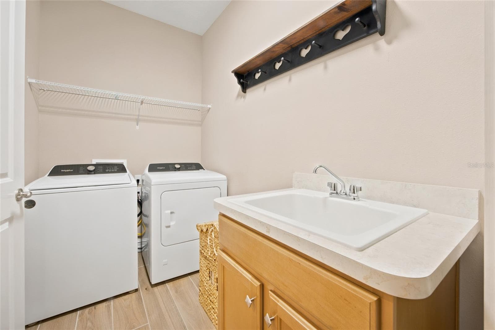 Interior laundry room with utility sink, cabinetry, washer and dryer. - 4497 NW 54TH TER, OCALA
