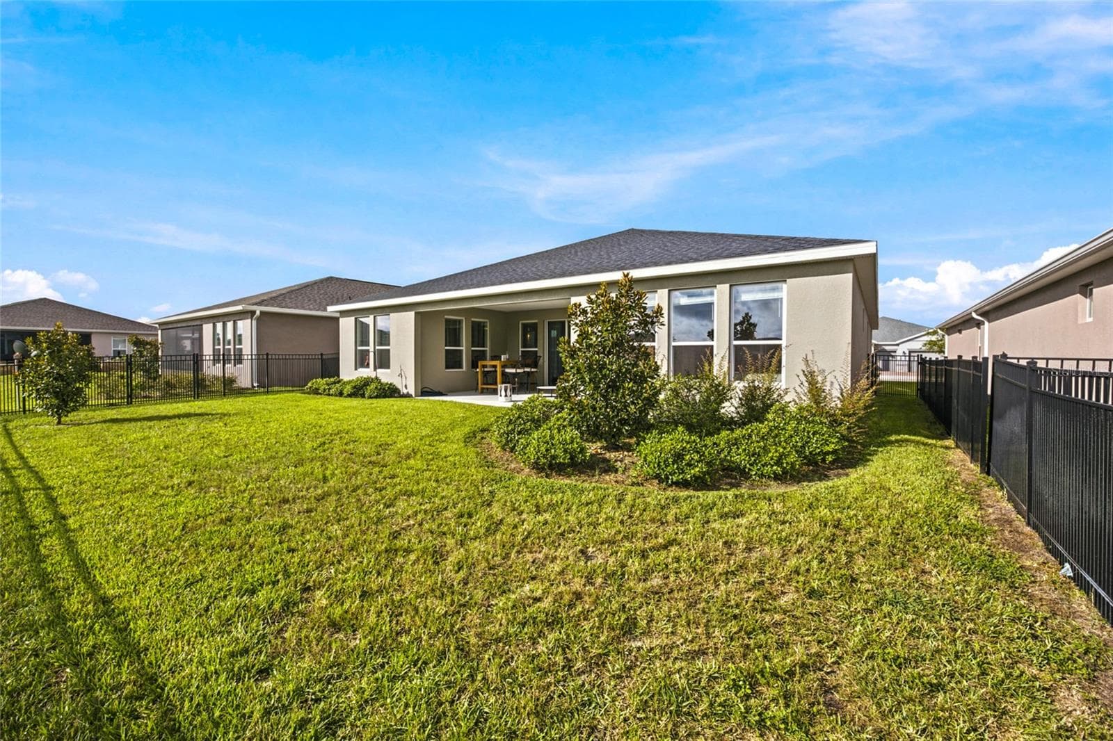 Fenced backyard with lawn space, mature landscaping and a covered rear patio. - 4497 NW 54TH TER, OCALA