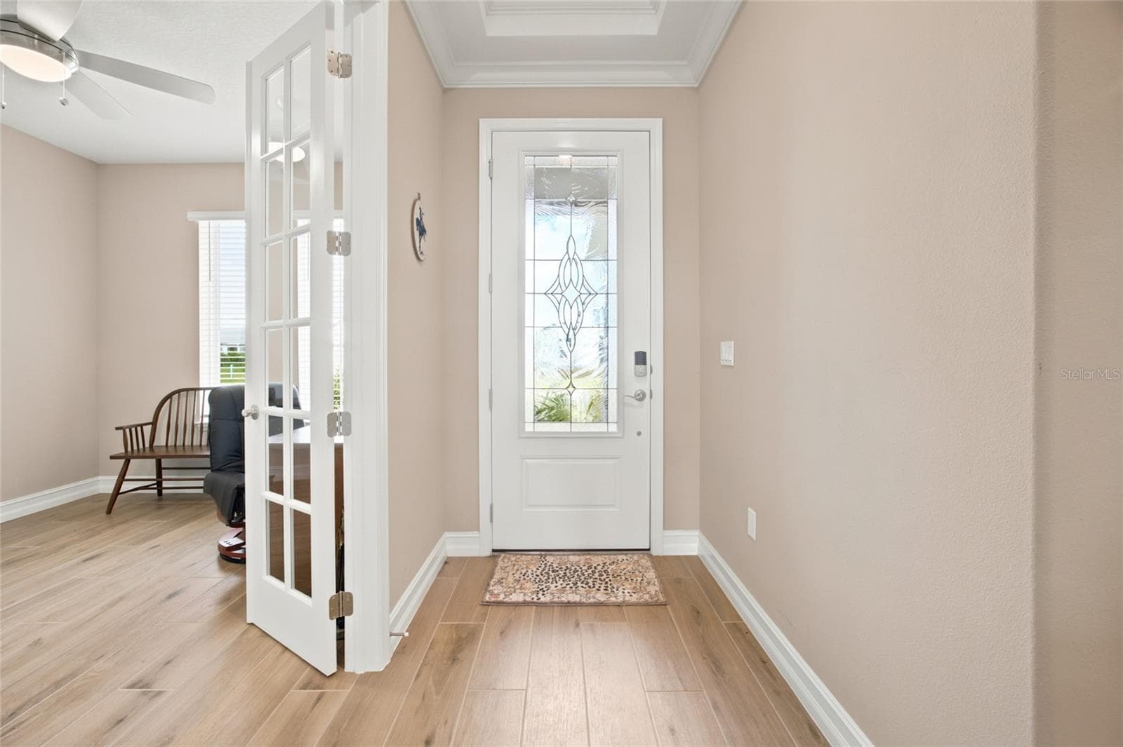 Welcoming foyer with wood-look tile flooring and French doors leading to the office. - 4497 NW 54TH TER, OCALA