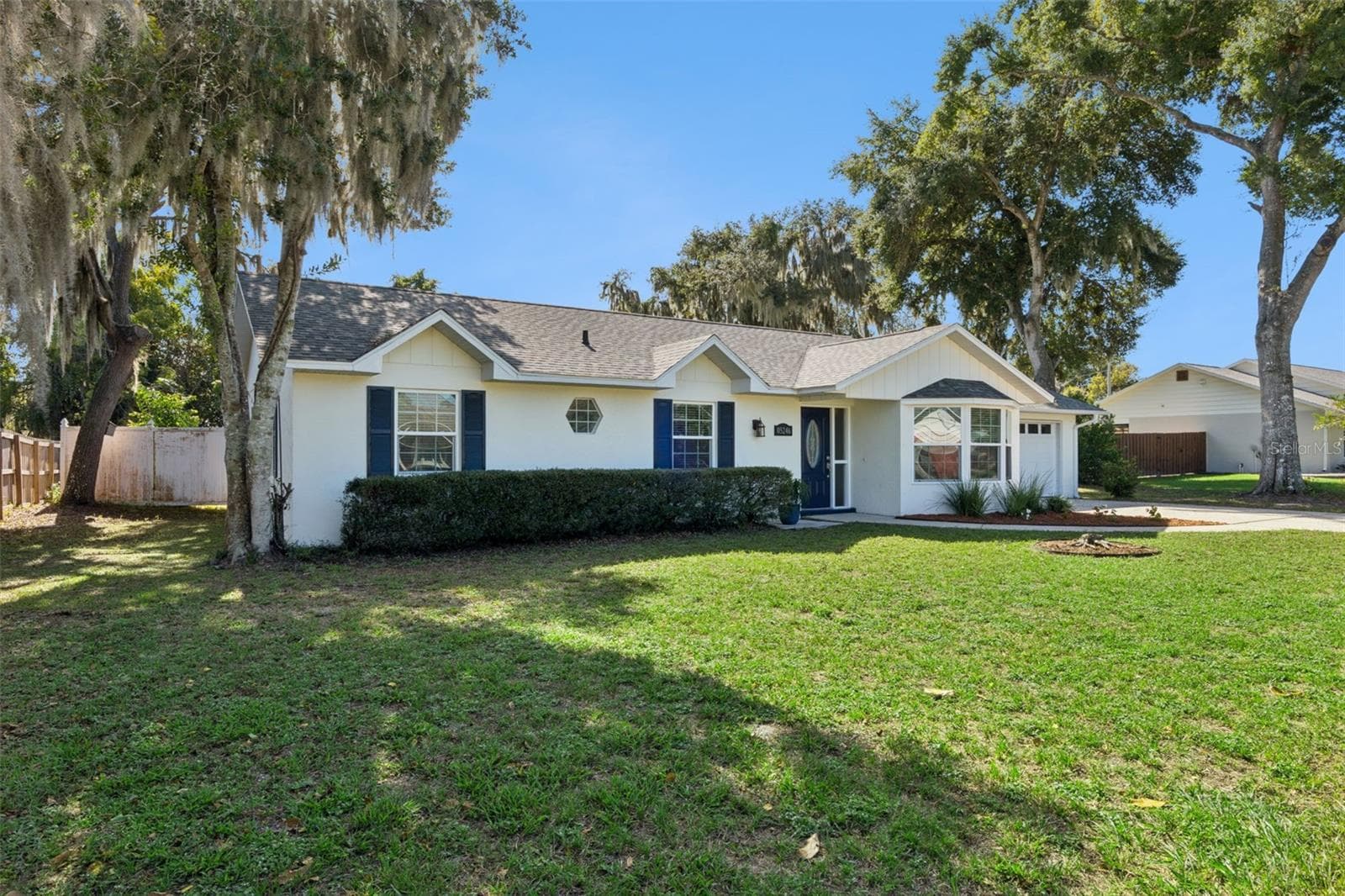 Classic curb appeal with navy shutters and a welcoming front door - 5246 ROYAL OAK DR, FRUITLAND PARK