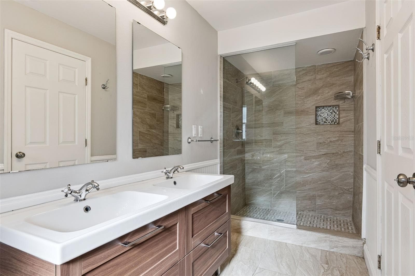 Tiled walk-in shower with a glass panel and dual sinks - 5246 ROYAL OAK DR, FRUITLAND PARK