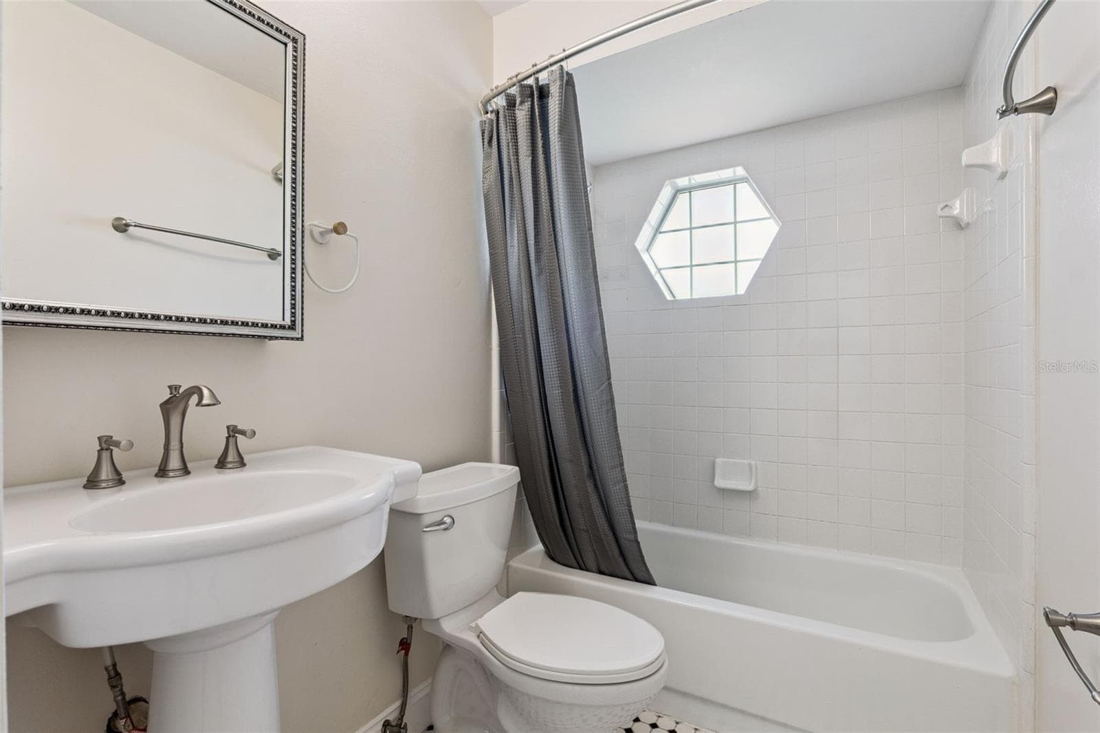 Guest bath with a tub/shower combo and a charming hexagon window - 5246 ROYAL OAK DR, FRUITLAND PARK