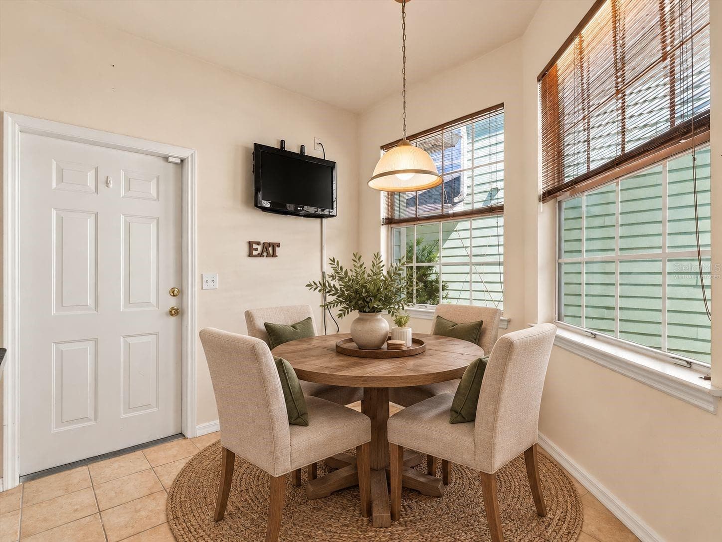 Virtually Staged - Dinette with light from windows and mounted TV and Door to Garage. - 11644 NW 18TH PL, GAINESVILLE