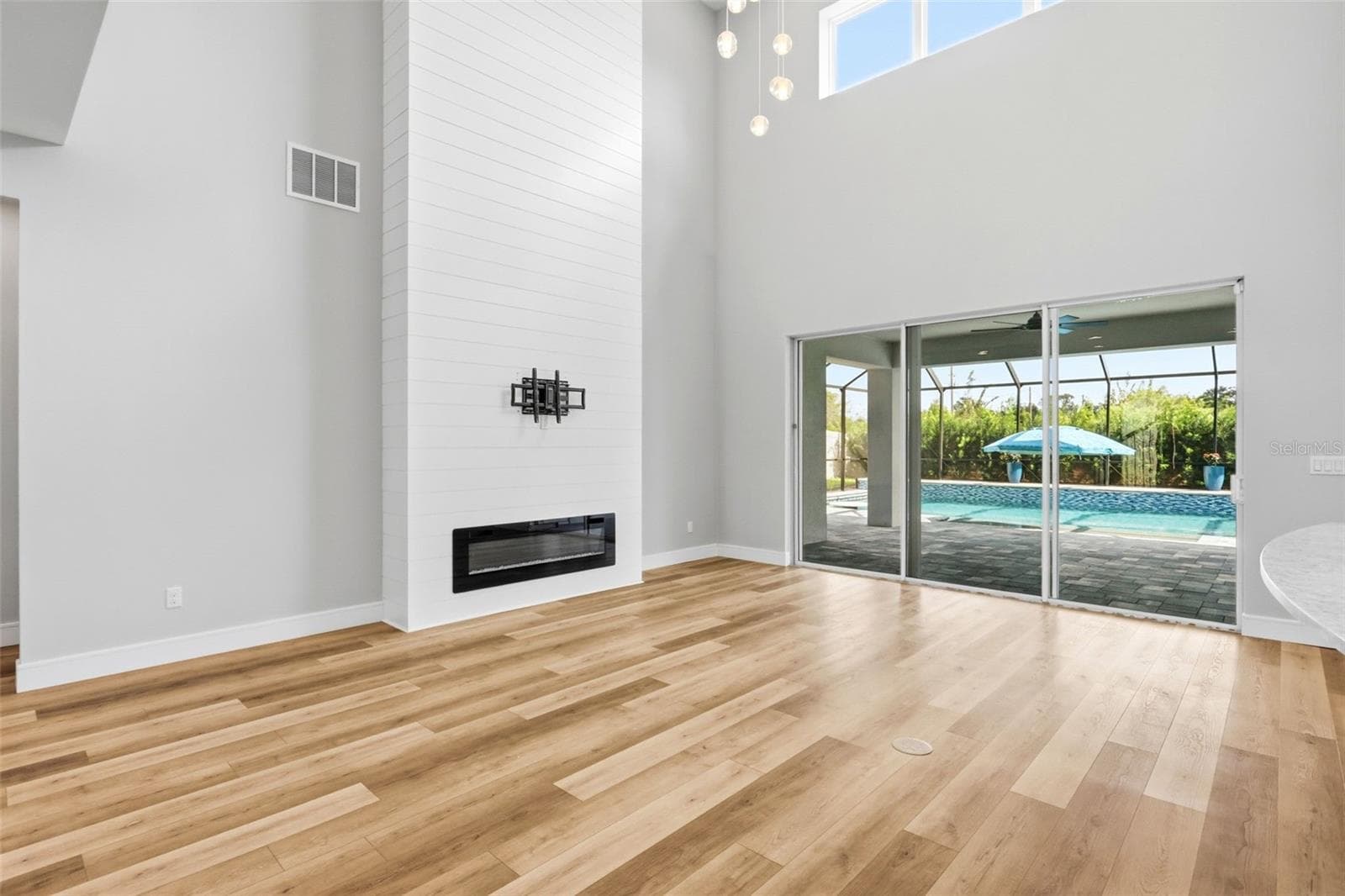 Soaring ceilings the the living area with sliding doors out to the covered lanai and enclosed pool. - 1552 MYRTLE OAKS TRL, OVIEDO