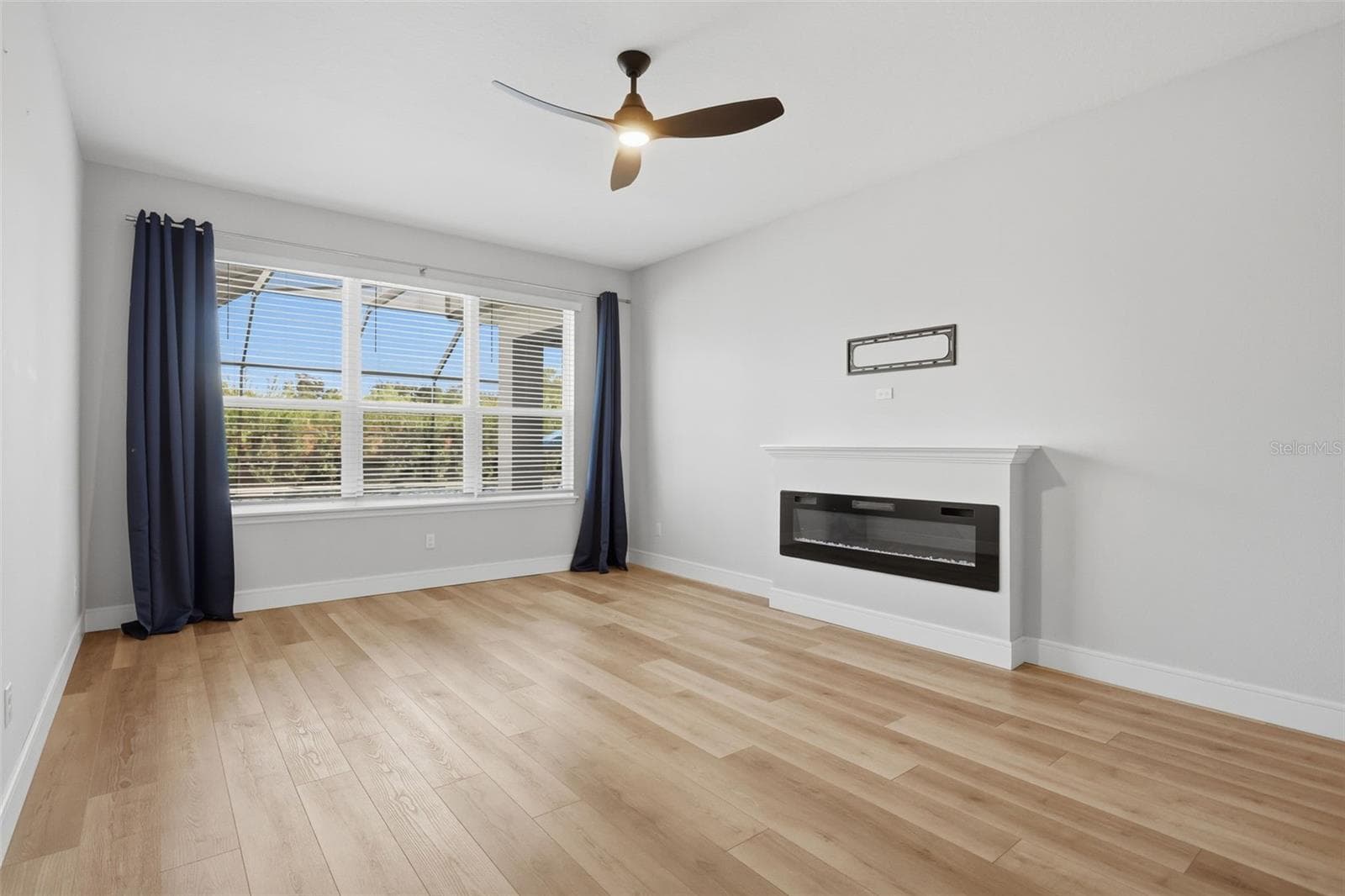 Primary bedroom downstairs features a fireplace and large windows providing a view of the pool - 1552 MYRTLE OAKS TRL, OVIEDO