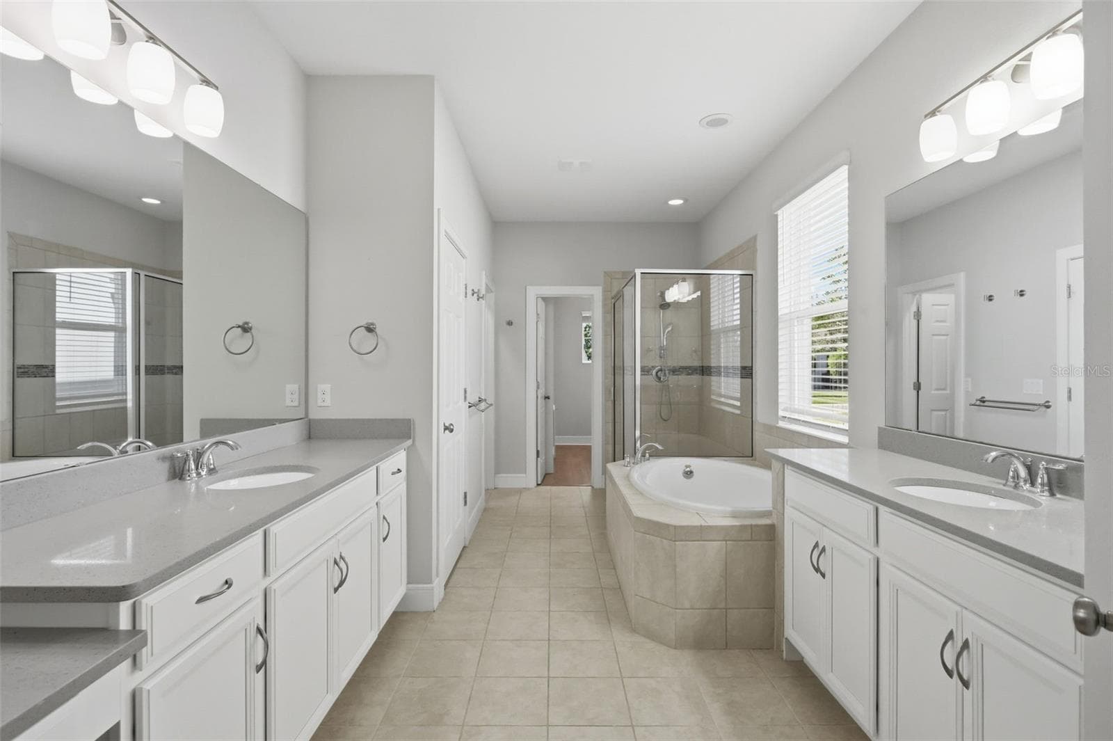 Primary bathroom features two vanities, 2 walk-in closets, garden tub and large shower - 1552 MYRTLE OAKS TRL, OVIEDO