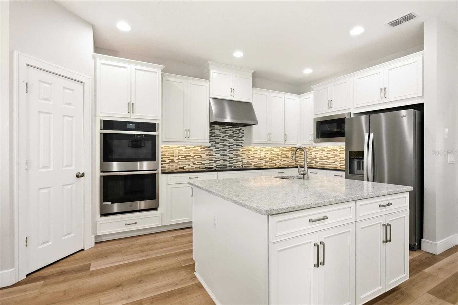 Double ovens in the kitchen with a prep island - 1552 MYRTLE OAKS TRL, OVIEDO