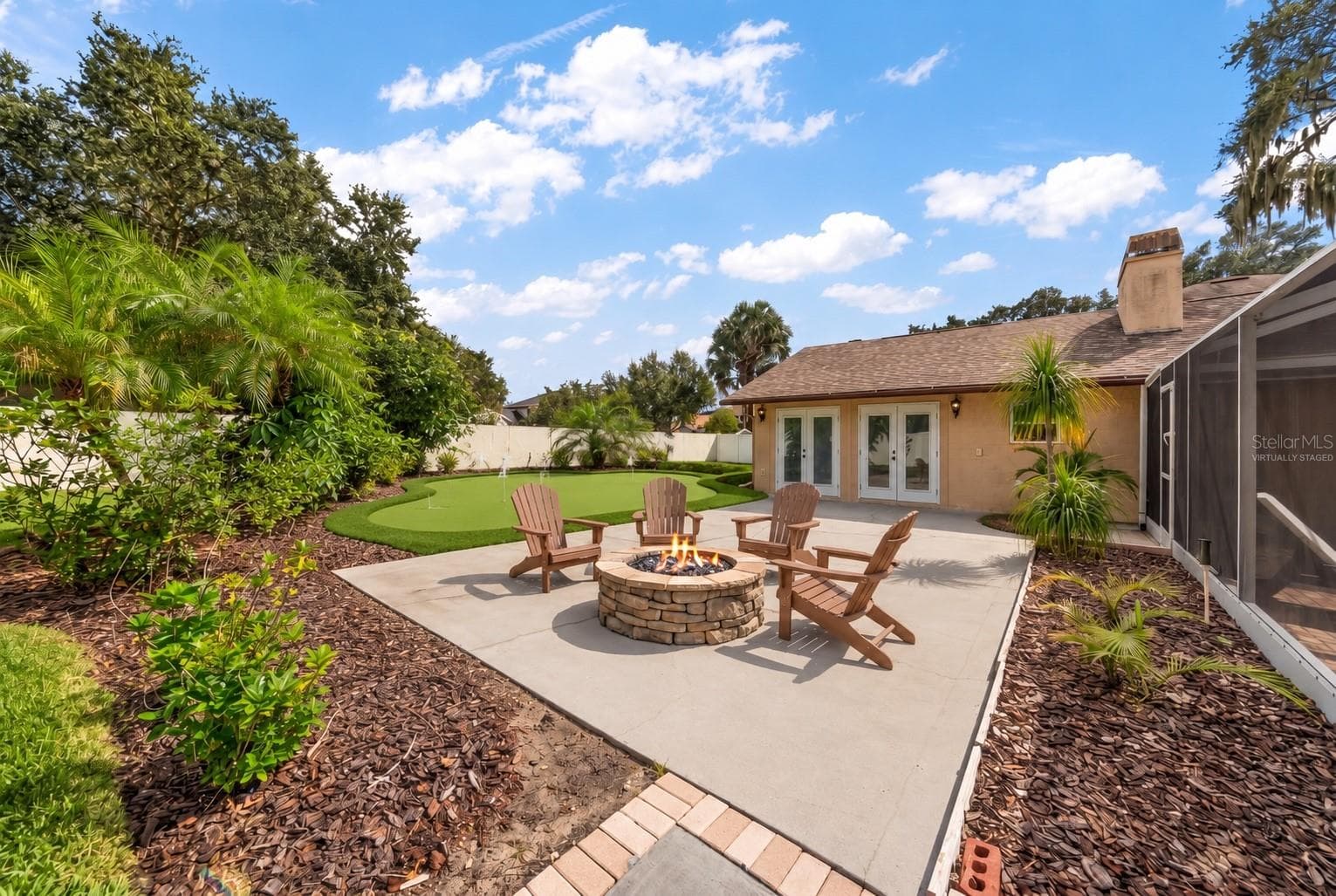 Looking out from patio with virtually staged fire-pit and putting green. - 1105 DEER RUN PL, VALRICO