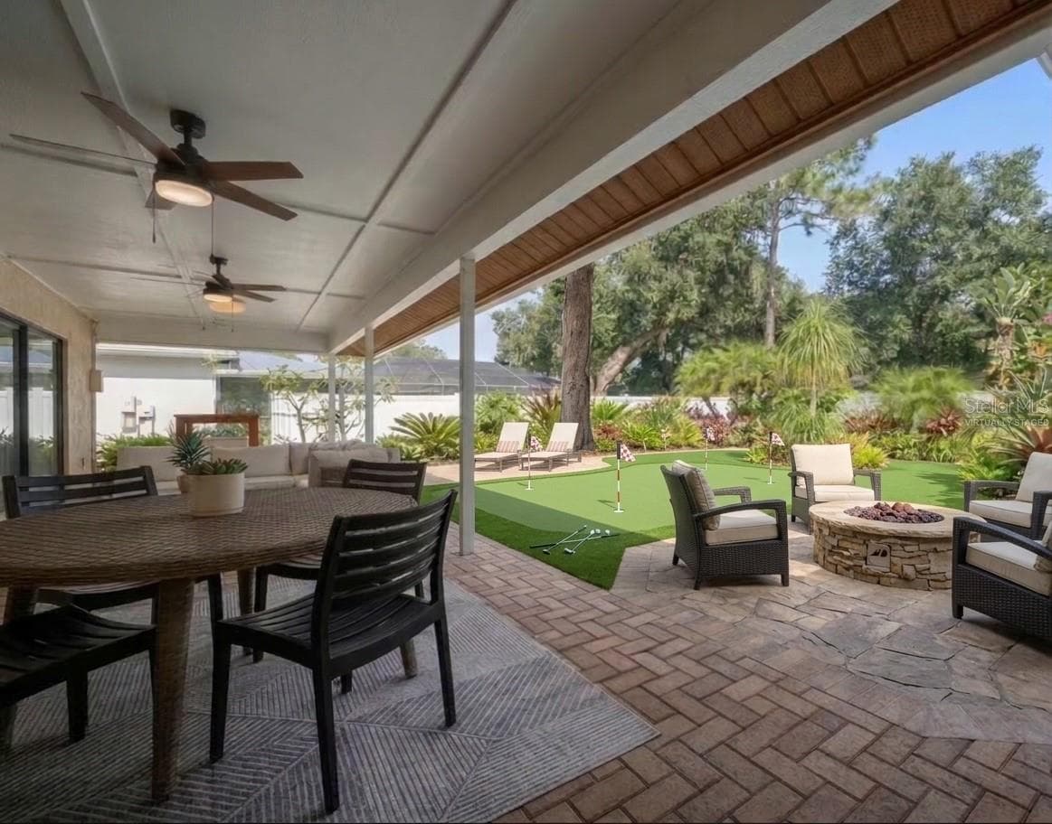 Looking out from patio with virtually staged fire-pit and putting green. - 1105 DEER RUN PL, VALRICO