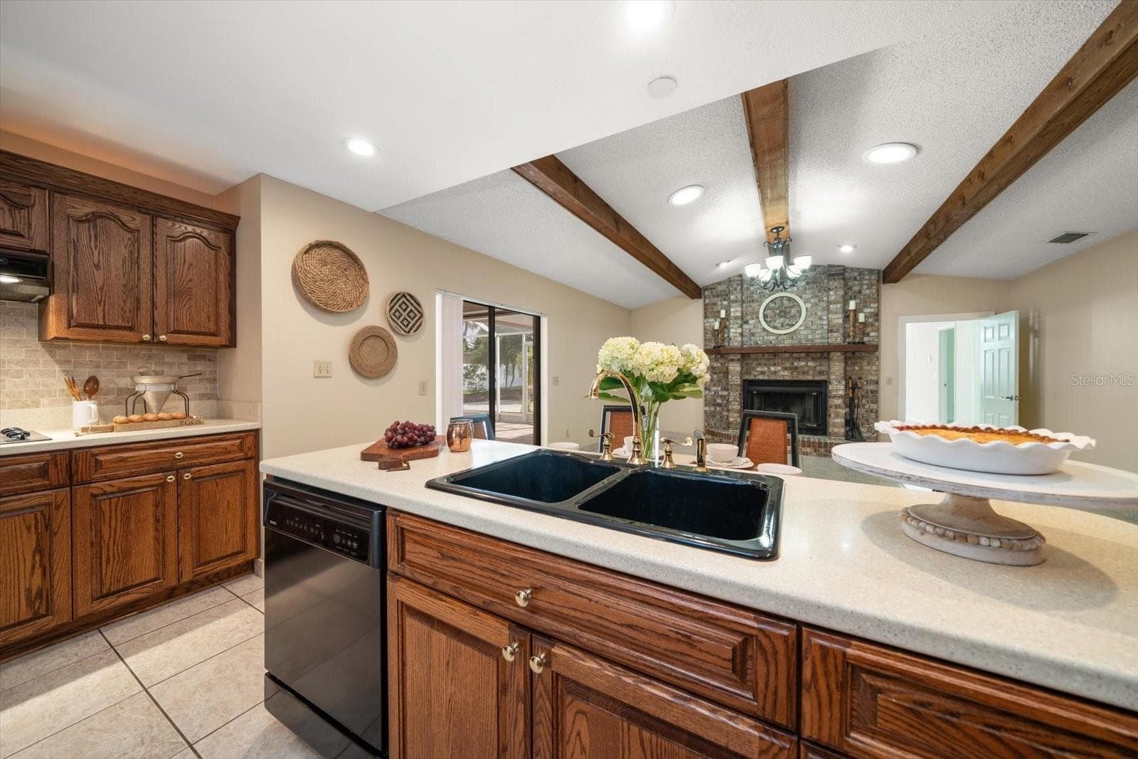 Warm and inviting great room with kitchen, eating and family room with masonry fireplace and beamed ceiling! - 1105 DEER RUN PL, VALRICO