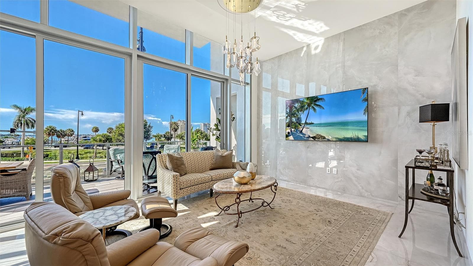 The grand great room showcases over 28 feet of soaring 12-foot floor-to-ceiling windows, capturing breathtaking panoramic views of Sarasota Bay. - 1155 N GULFSTREAM AVE #207, SARASOTA