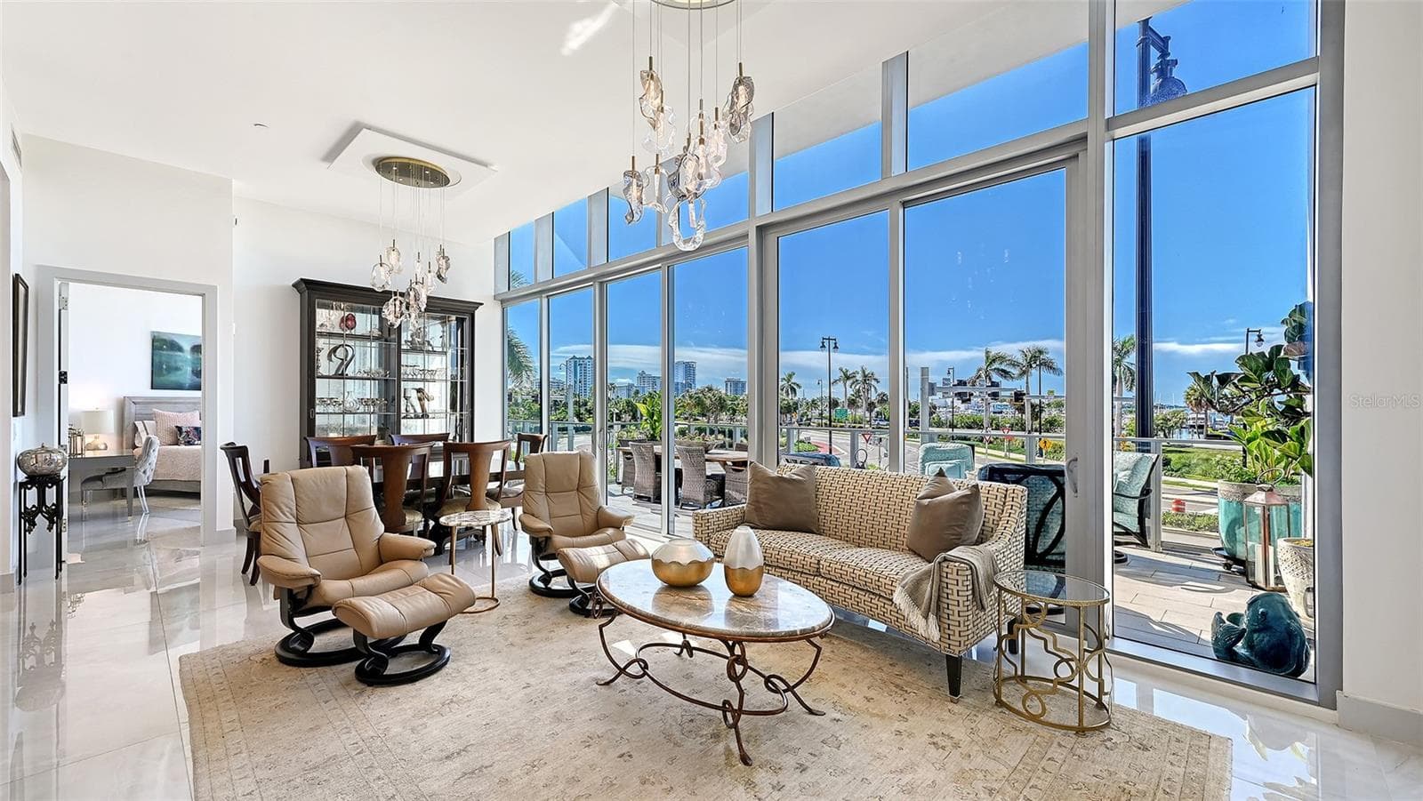 A sun-drenched, open-concept living space that flows seamlessly onto a private 533-square-foot balcony, showcasing spectacular panoramic waterfront views. - 1155 N GULFSTREAM AVE #207, SARASOTA