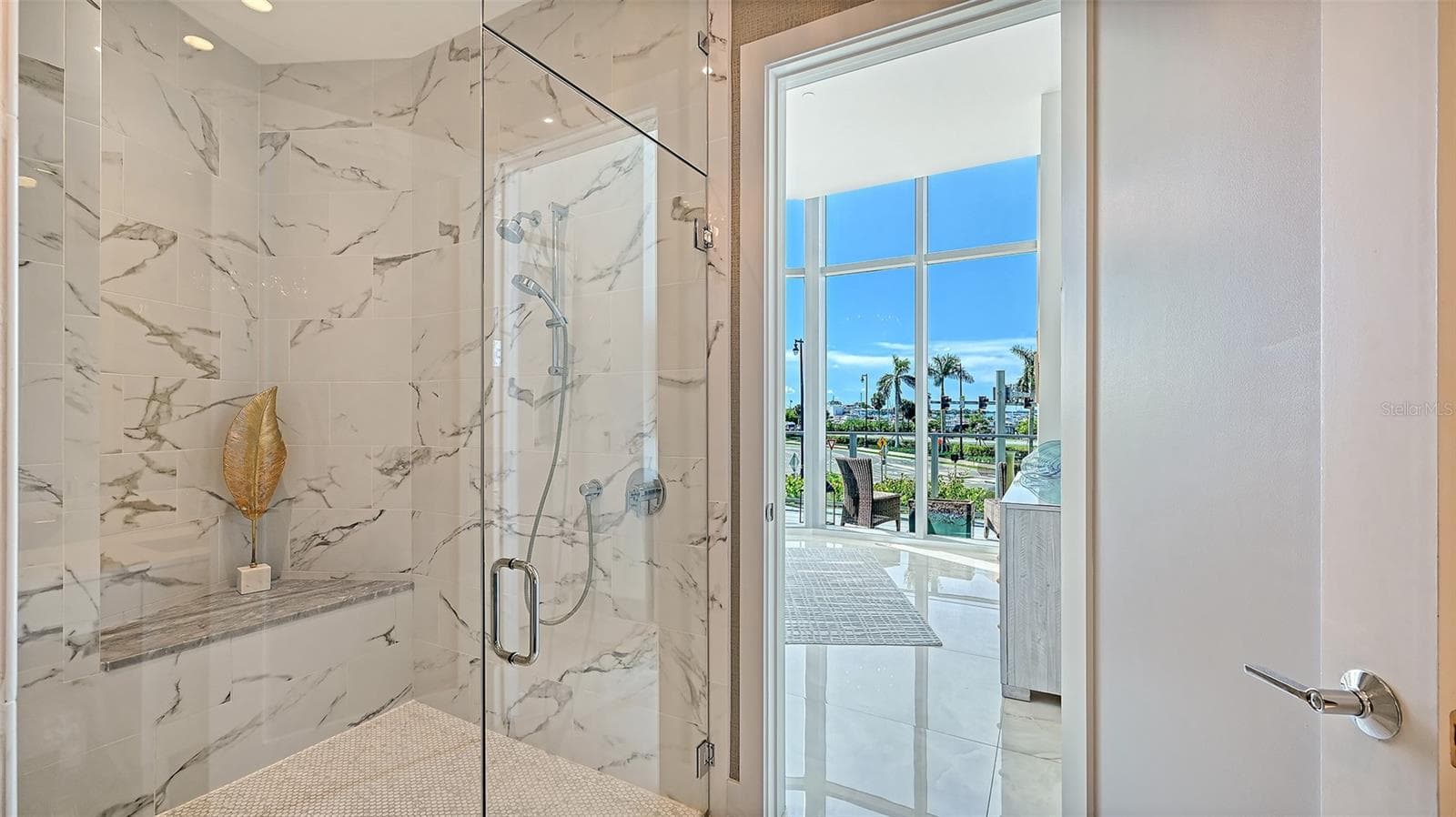A luxurious, oversized walk-in shower enclosed in sleek glass, offering a spa-inspired bathing experience. - 1155 N GULFSTREAM AVE #207, SARASOTA