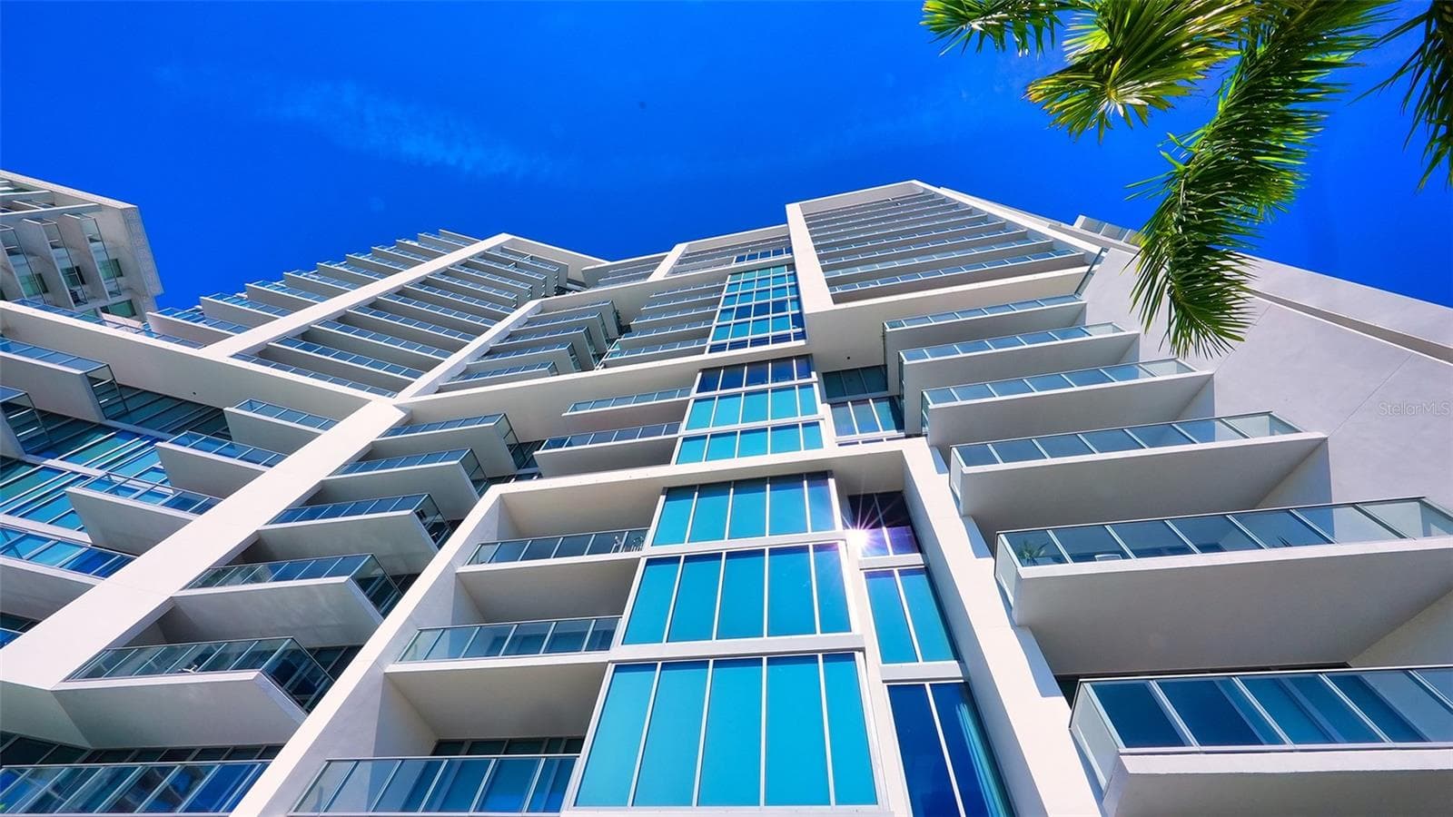 A striking upward perspective showcases The VUE’s iconic architecture, highlighting its distinctive design, soaring height, and impressive modern lines. - 1155 N GULFSTREAM AVE #207, SARASOTA