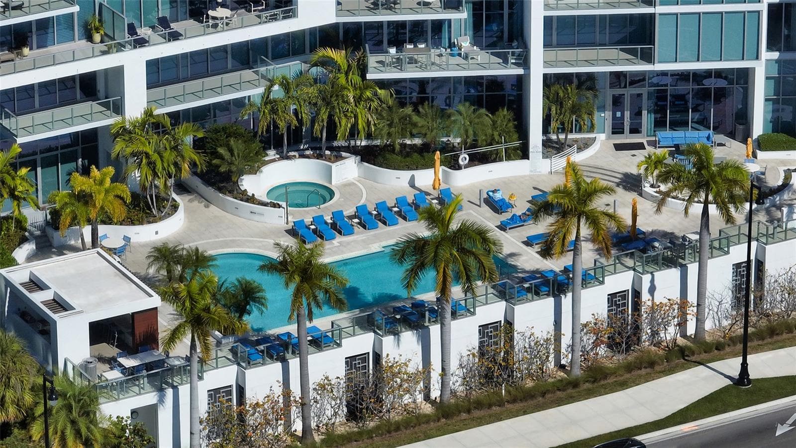 An aerial perspective showcasing The VUE’s striking architecture and beautiful resort-style pool, highlighting its exceptional design and luxurious waterfront setting. - 1155 N GULFSTREAM AVE #207, SARASOTA