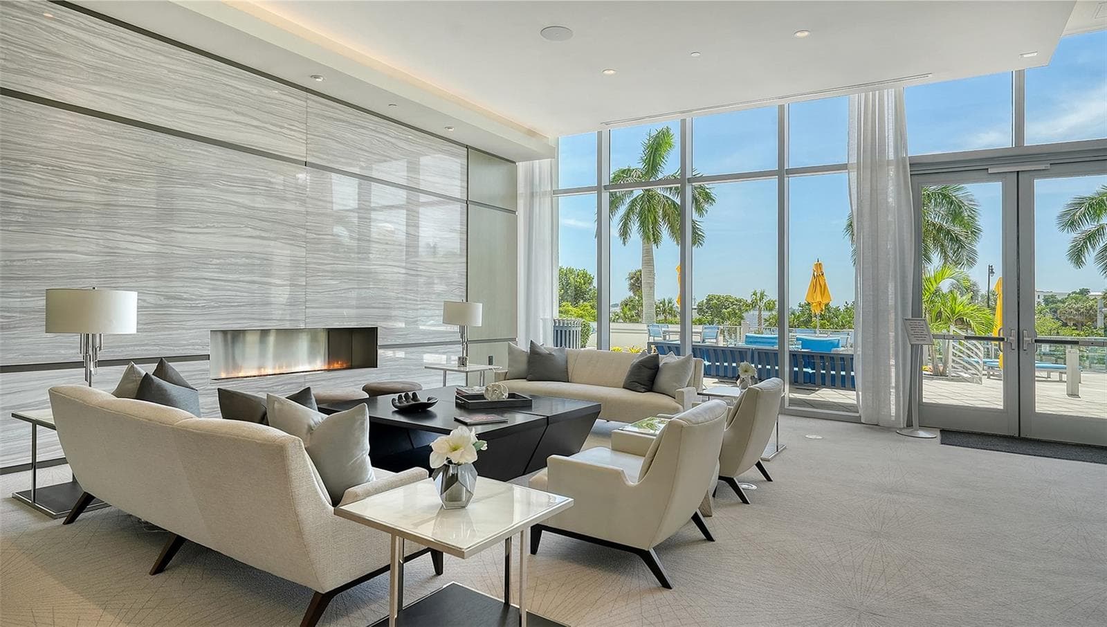 An expansive luxury lobby lounge featuring elegant seating and a welcoming fireplace, creating a sophisticated setting for relaxation and gathering with guests. - 1155 N GULFSTREAM AVE #207, SARASOTA