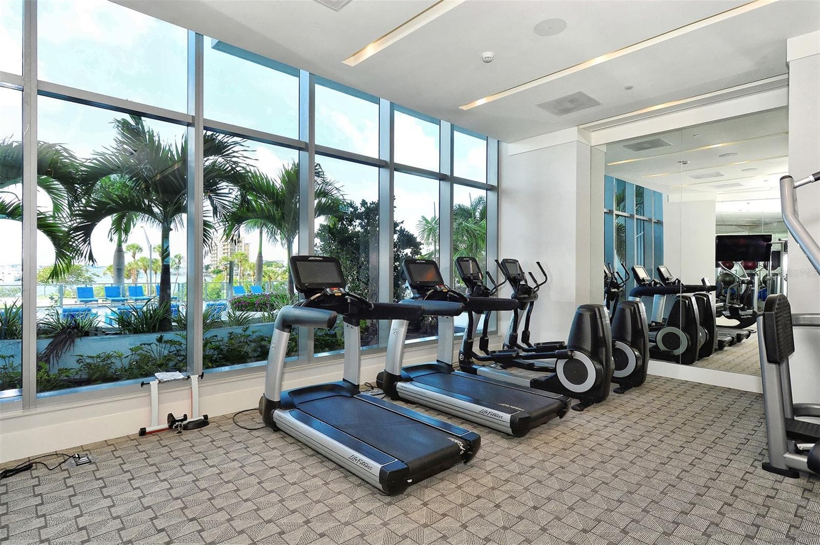 A state-of-the-art fitness center featuring panoramic views of the resort-style pool and Sarasota Bay. - 1155 N GULFSTREAM AVE #207, SARASOTA