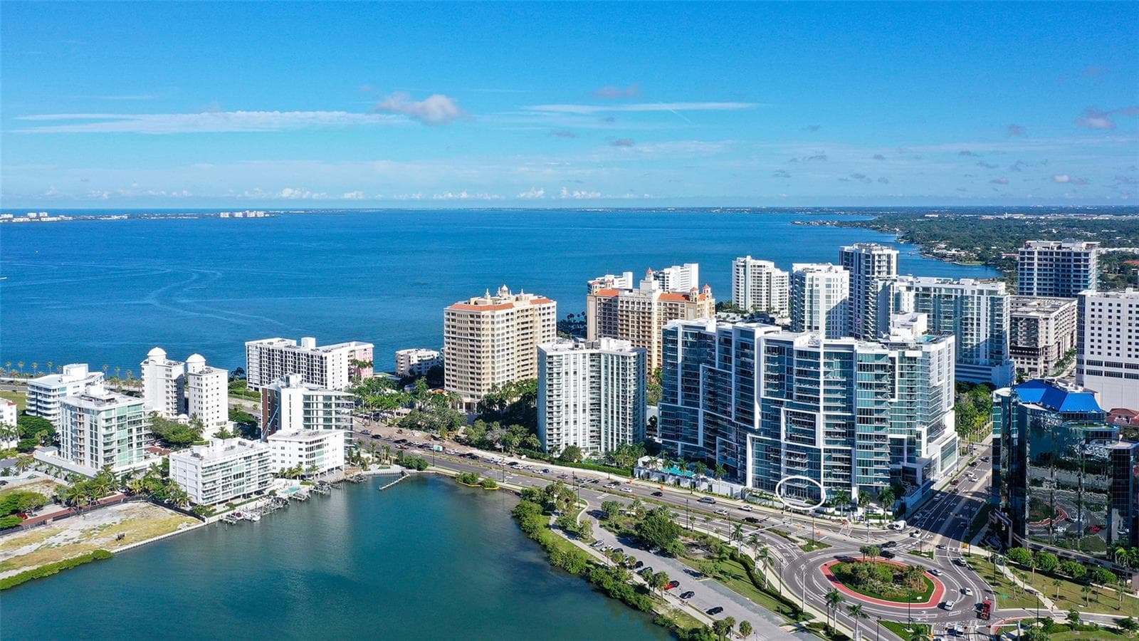 An aerial view showcases The VUE’s iconic waterfront architecture overlooking the sparkling waters of Sarasota Bay toward Longboat Key. - 1155 N GULFSTREAM AVE #207, SARASOTA