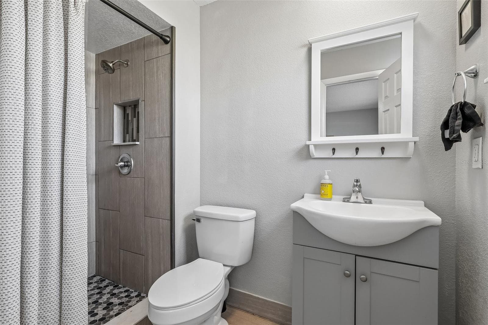 The primary bathroom has an updated stand-up shower, vanity, and decorative mirror - 1332 BOREAS DR, ORLANDO