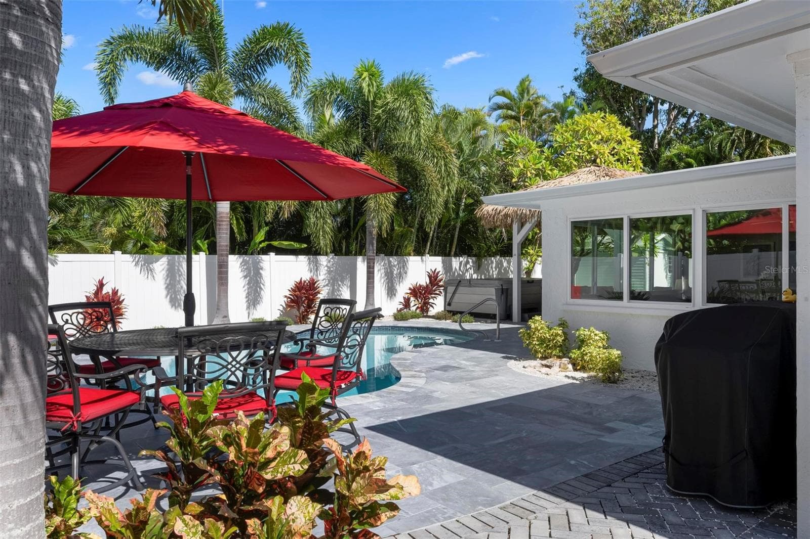 Pavered outdoor pool patio with heated saltwater pool and hot tub - 504 69TH ST, HOLMES BEACH