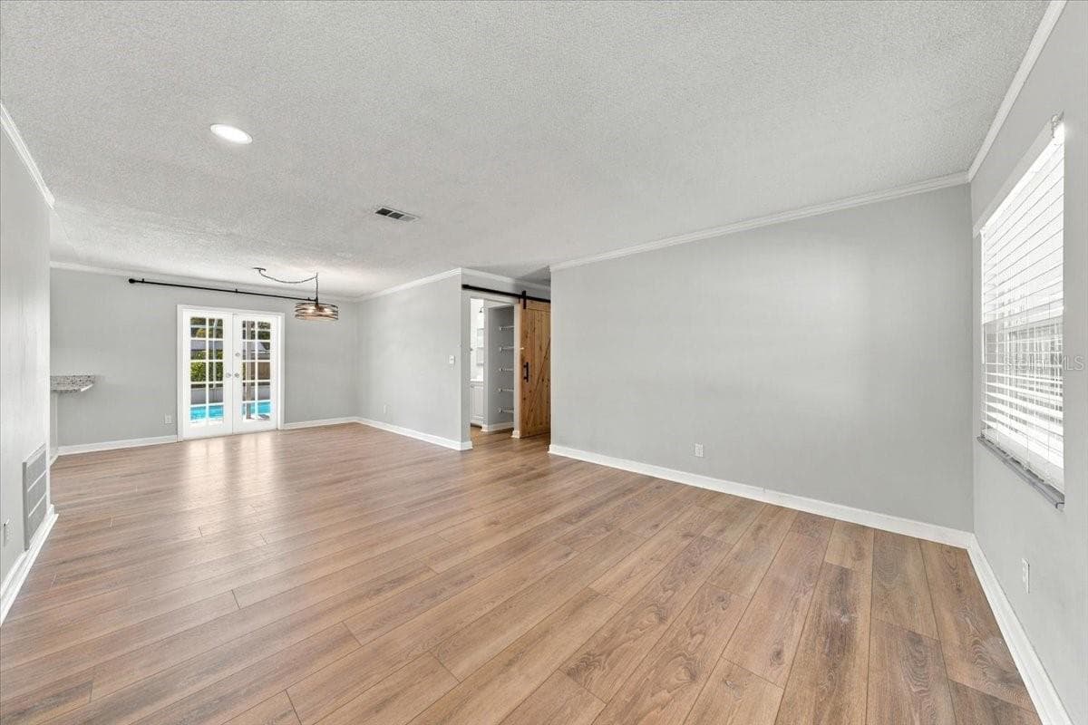 Living room and dining area with french doors to the pool - 5220 90TH TER N, PINELLAS PARK
