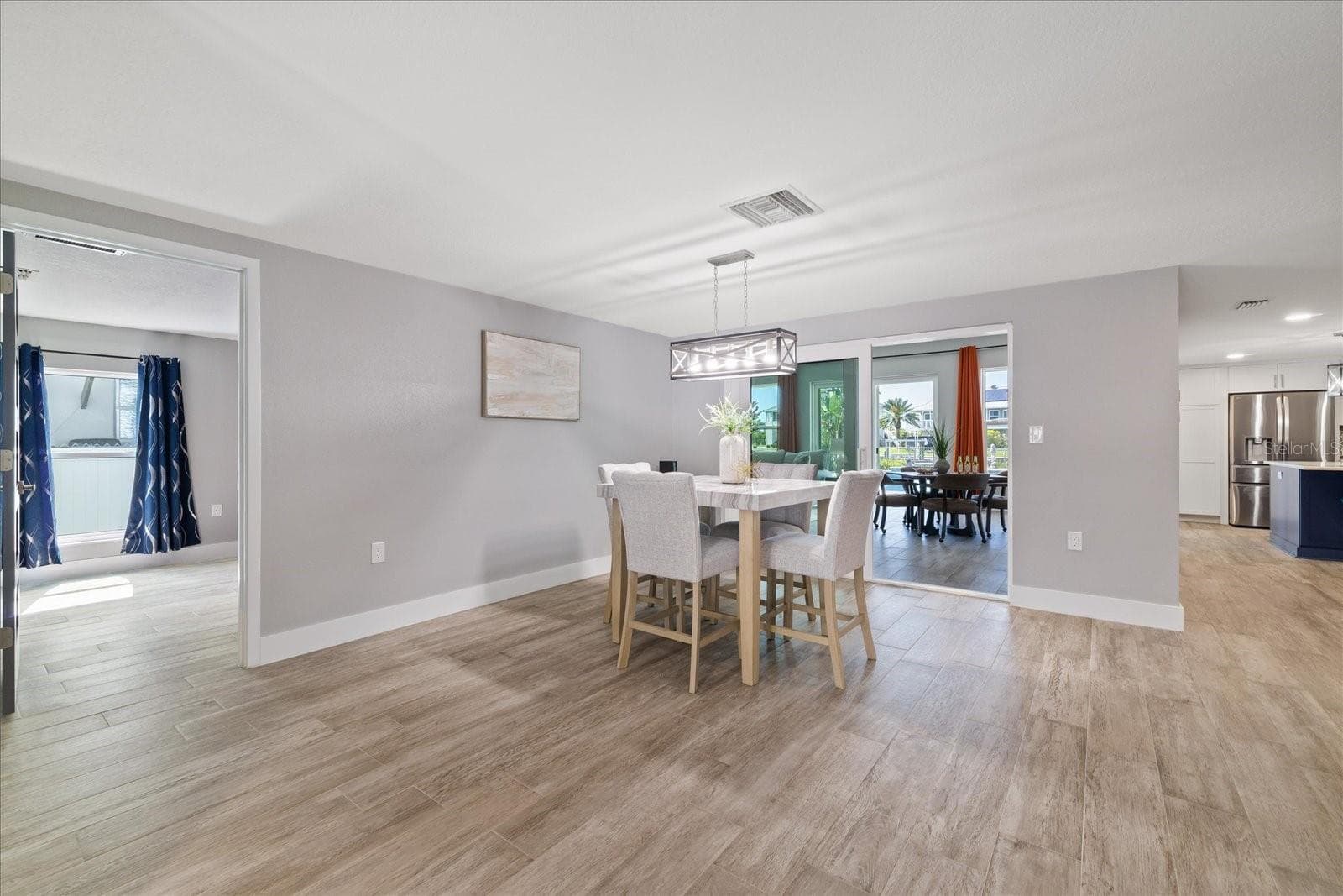 View from entry of primary bedroom entry and family room sliders past dining table - 5001 MARLIN DR, NEW PORT RICHEY