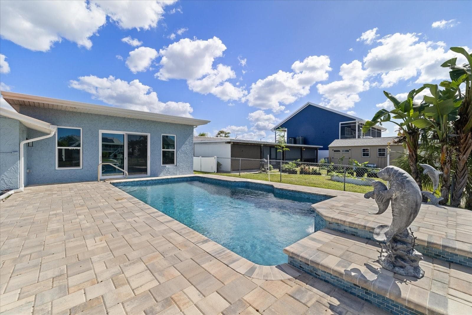 Pavered pool deck with dolphin accents and waterfall feature - 5001 MARLIN DR, NEW PORT RICHEY