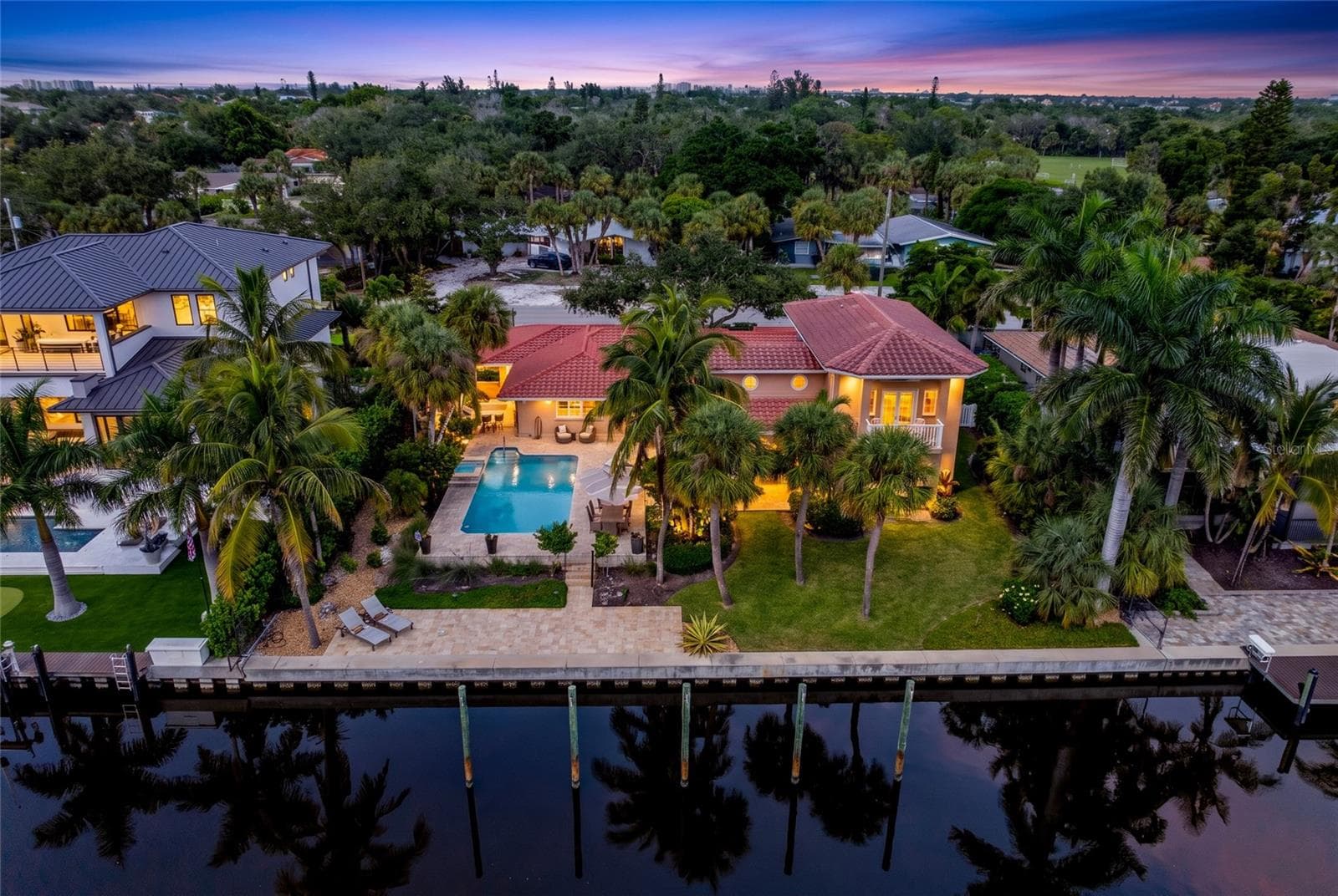Aerial view of 5376 Shadow Lawn Drive showcasing the home's canal frontage, pool, tropical setting and Siesta Key waterfront lifestyle. - 5376 SHADOW LAWN DR, SARASOTA