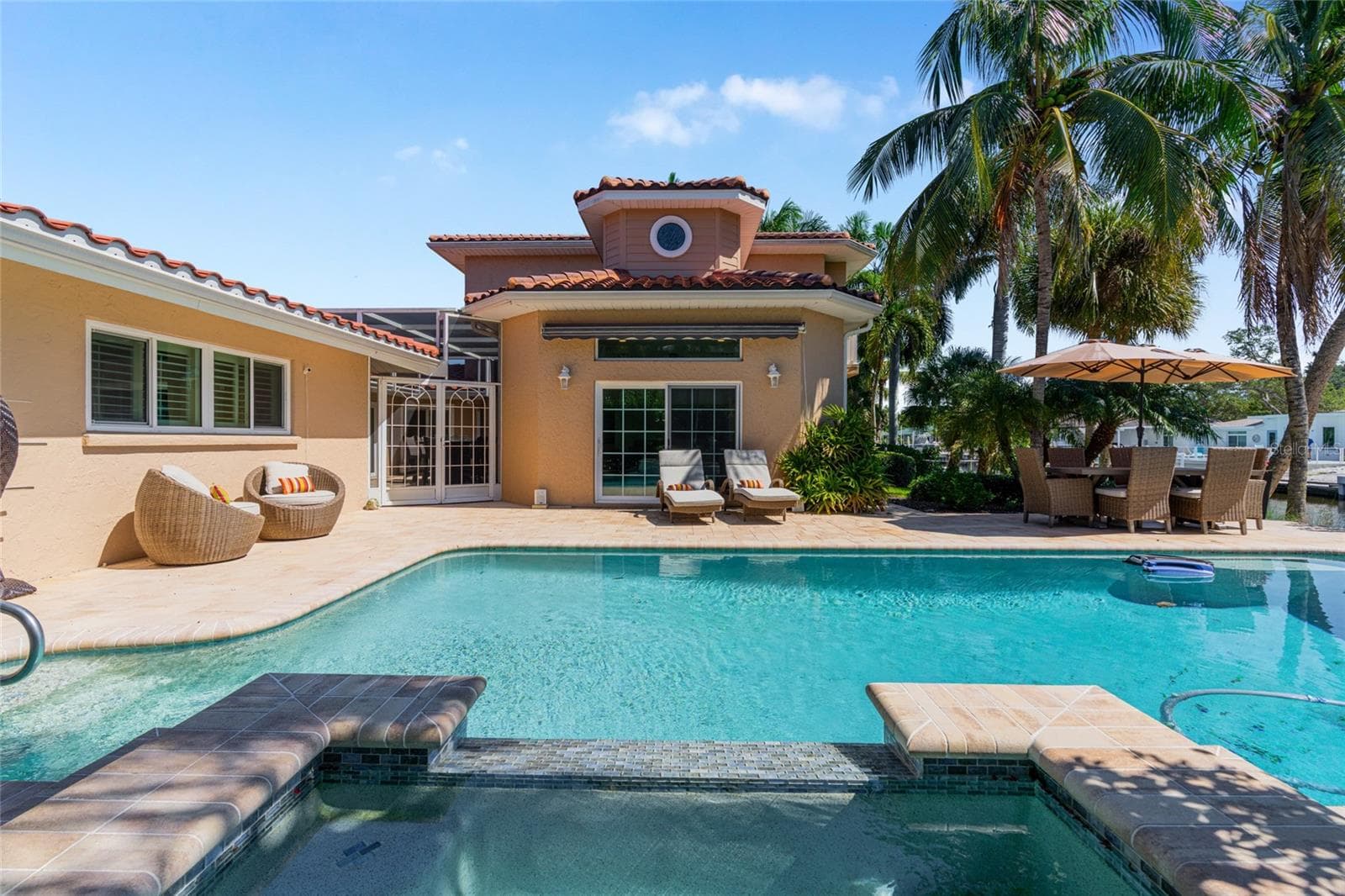 Poolside view toward the home highlights the scale of the outdoor living area and lush tropical surroundings. - 5376 SHADOW LAWN DR, SARASOTA