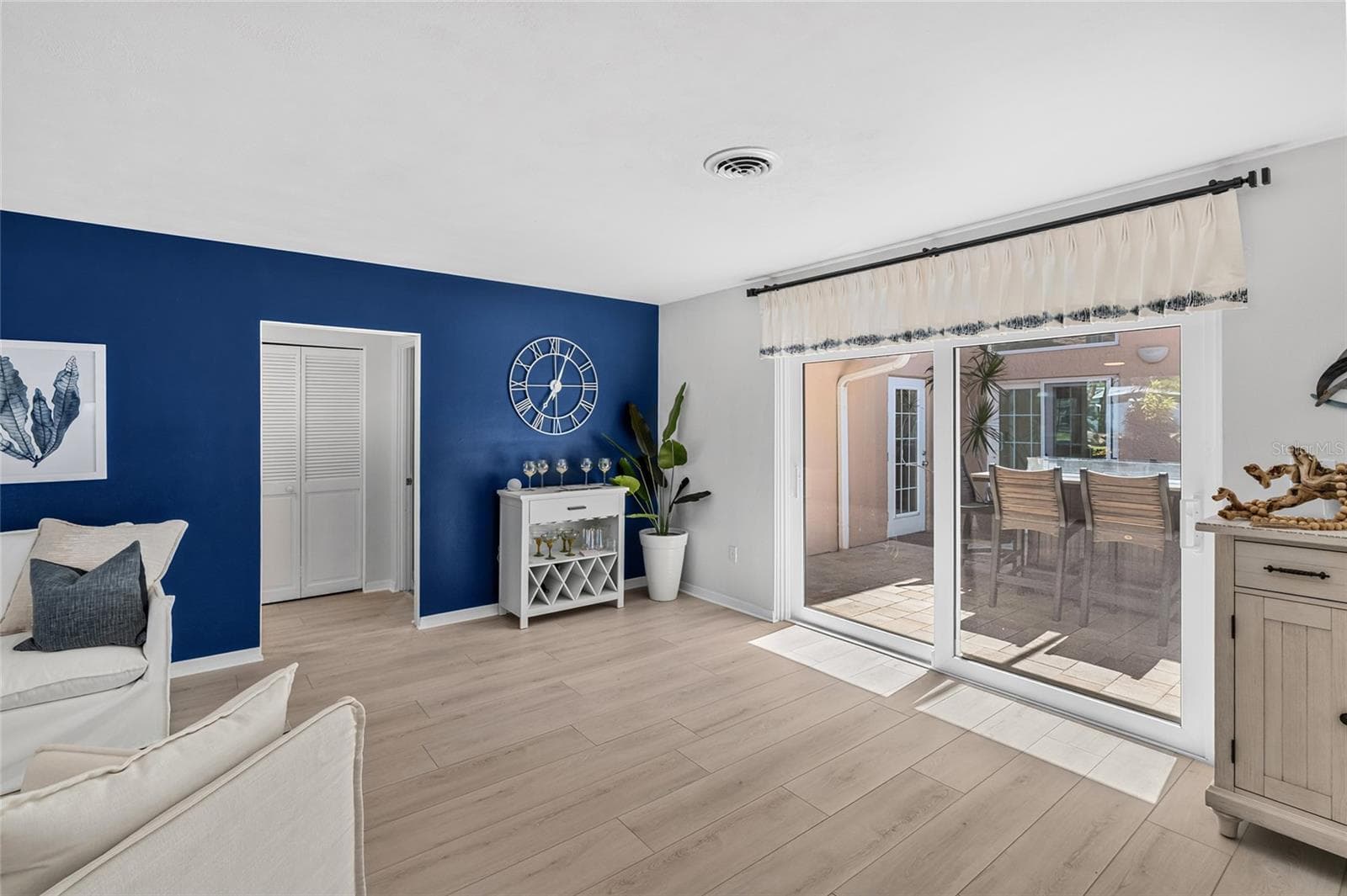 Living area opens directly to the screened courtyard lanai with tabletop fire pit and access toward the pool. - 5376 SHADOW LAWN DR, SARASOTA